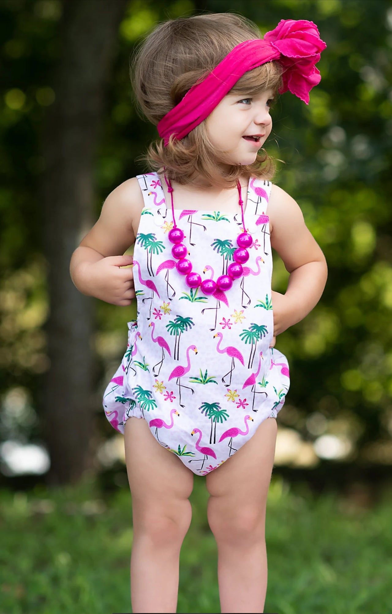 Little toddler girl wearing a pink flamingo print boho baby romper 