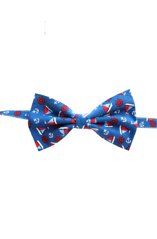 Blue bowtie with a sailboat ships print. The boat has blue and red color on it. 