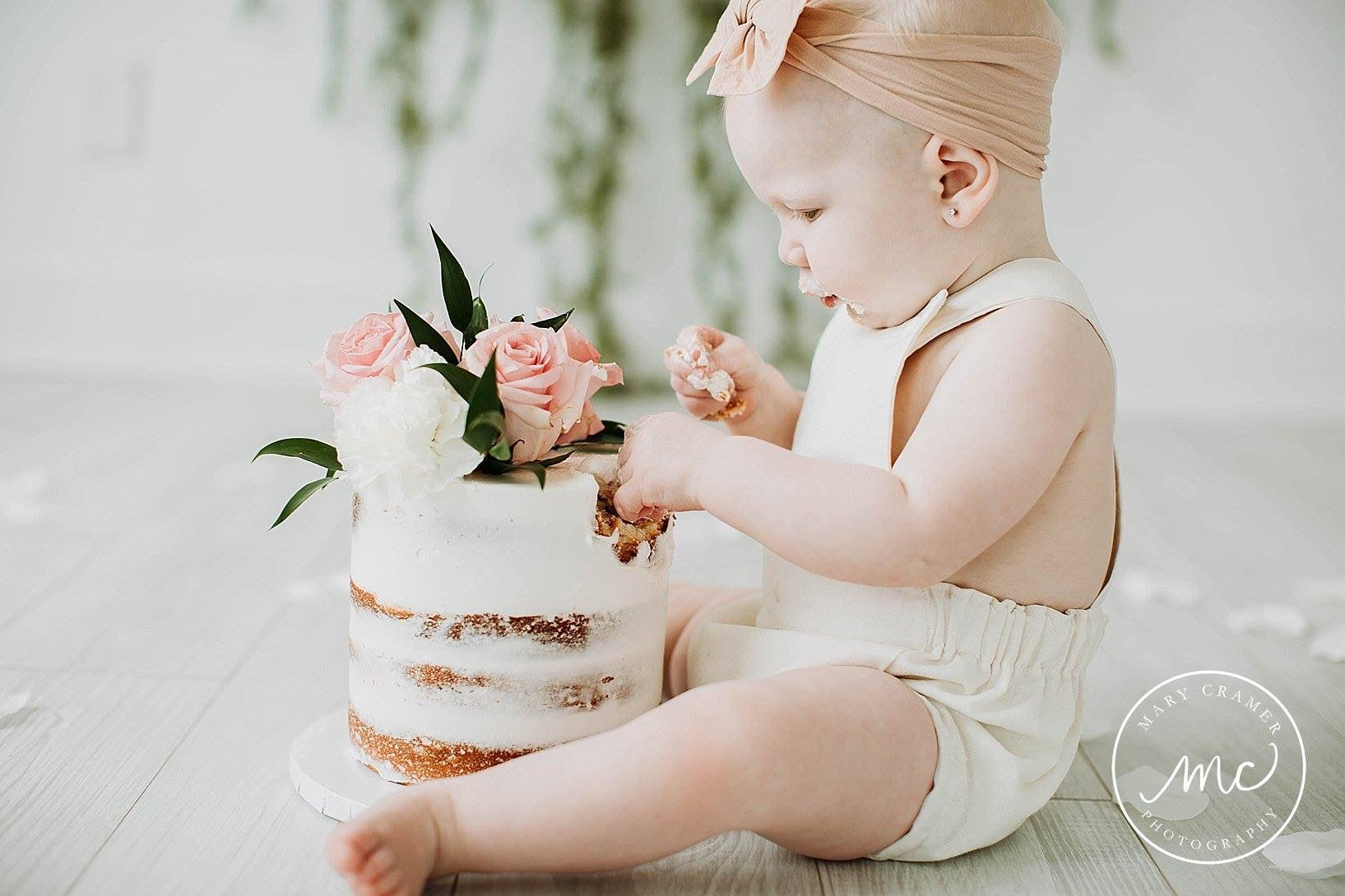 First birthday cake smash photoshoot with Ackee Tree Clothing bleached white linen blend boho romper on this sweet little baby.