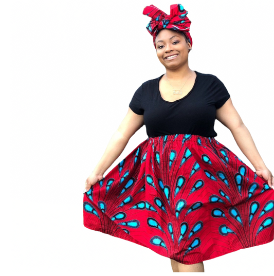 African American woman wearing an African print skirt set which includes a headwrap. The skirt set is red with blue print.