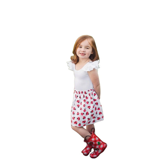 Little girl wearing white skirt with red and black ladybug skirt. The skirt has an elastic waistband. 