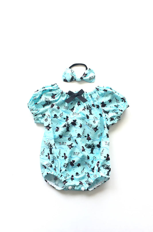 Alice in Wonderland Romper in Blue and White prints. Scenes depicted from Alice in Wonderland on this cotton fabric. The baby romper is a peasant neckline with elastic sleeves and snaps at the crotch of the romper. 