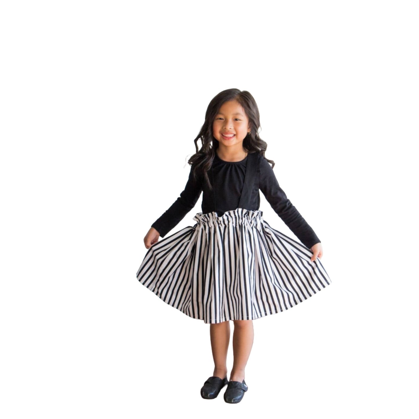 A gorgeous Asian little girl wearing a black and white striped suspender skirt that ties in the back. Front view of the suspender skort.